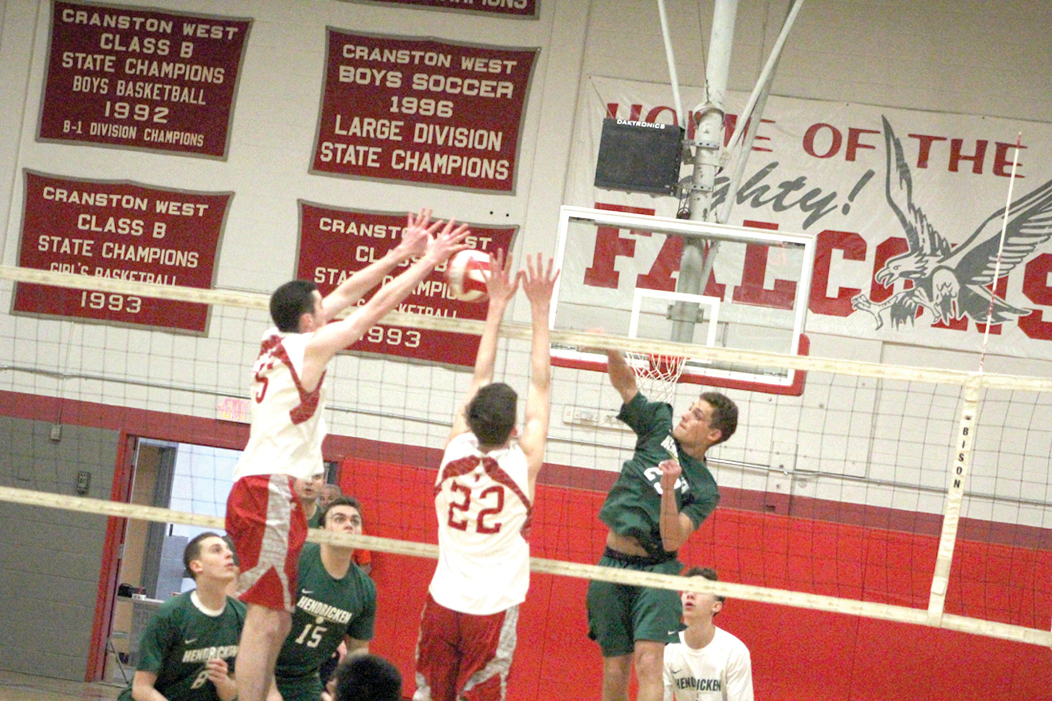 BLASTOFF: Bishop Hendricken’s Jose Lamendola blasts a spike towards two defenders from the Cranston West     Falcons during their game on Tuesday. The Hawks swept the game in three sets, all by a score of 25-20.